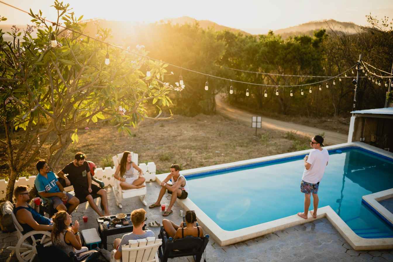 People wearing casual BBQ outfit ideas by a pool.