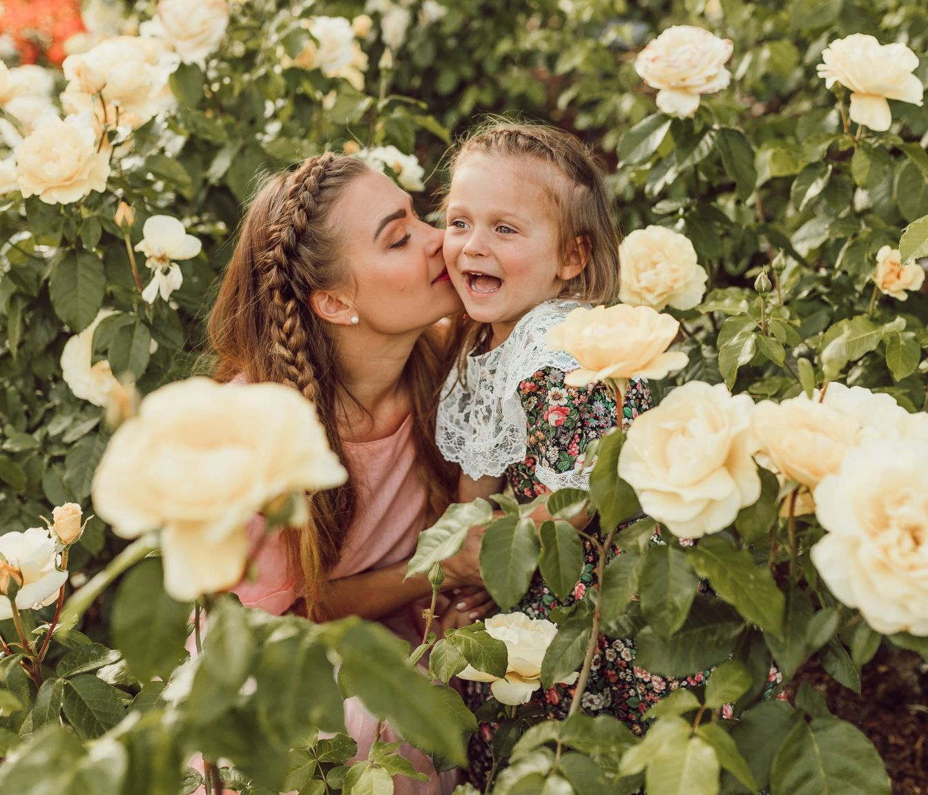 Mother and daughter in a rose bush